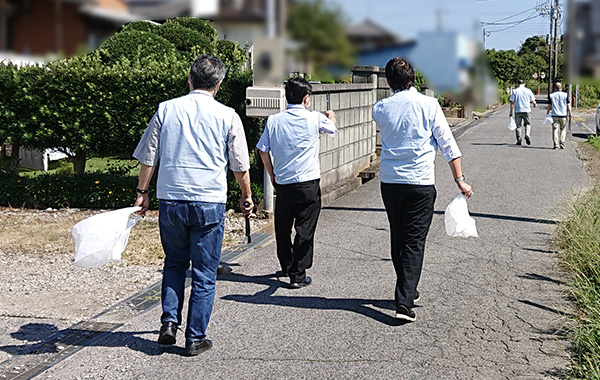 地域を回りながら清掃活動を行う女性社員